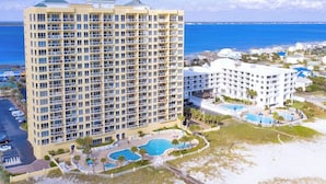 A high-rise hotel with multiple balconies, a swimming pool, and a beach view. - Beautiful 3 Bed, 2 Bath Gulf Front Condo/Free Platinum Beach Service! (Pensacola Beach)