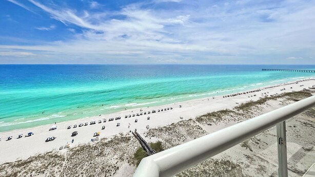 A beach with a pier extending into the ocean, clear skies, and a calm sea. - Beautiful 3 Bed, 2 Bath Gulf Front Condo/Free Platinum Beach Service! (Pensacola Beach)