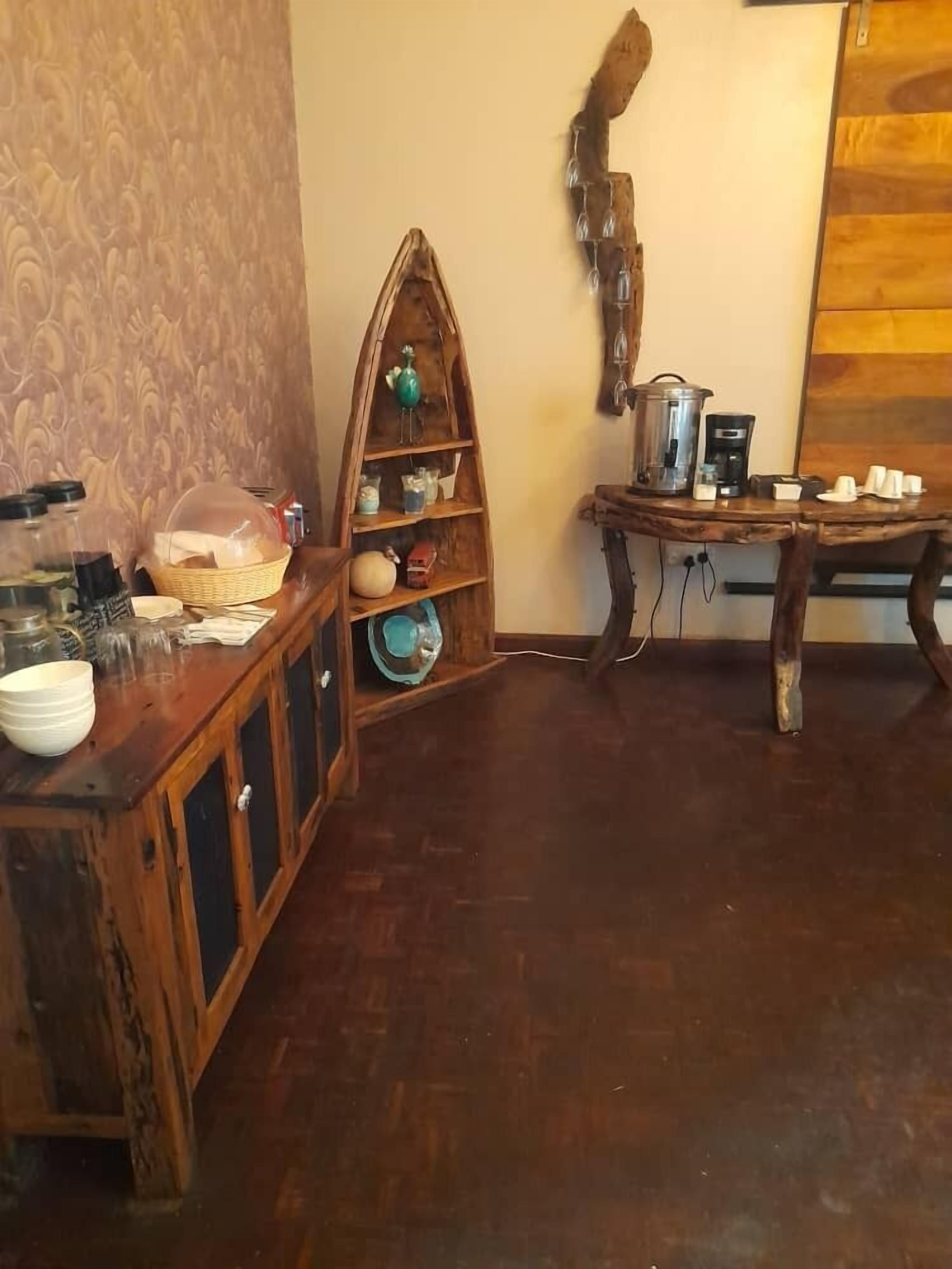 A wooden cabinet with shelves, a decorative wooden structure, and a coffee station.