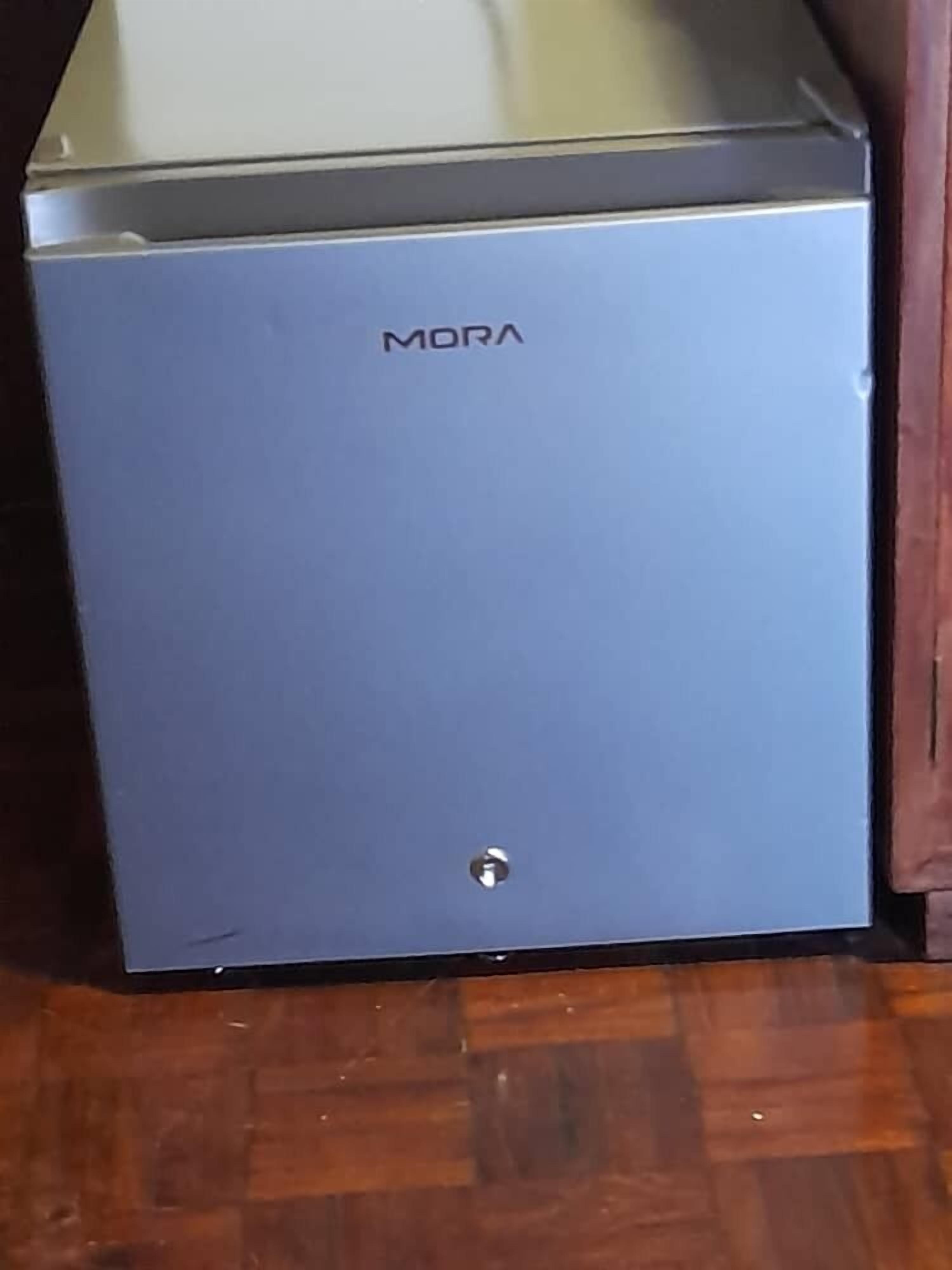 A blue refrigerator with the brand name 'MORA' on it.
