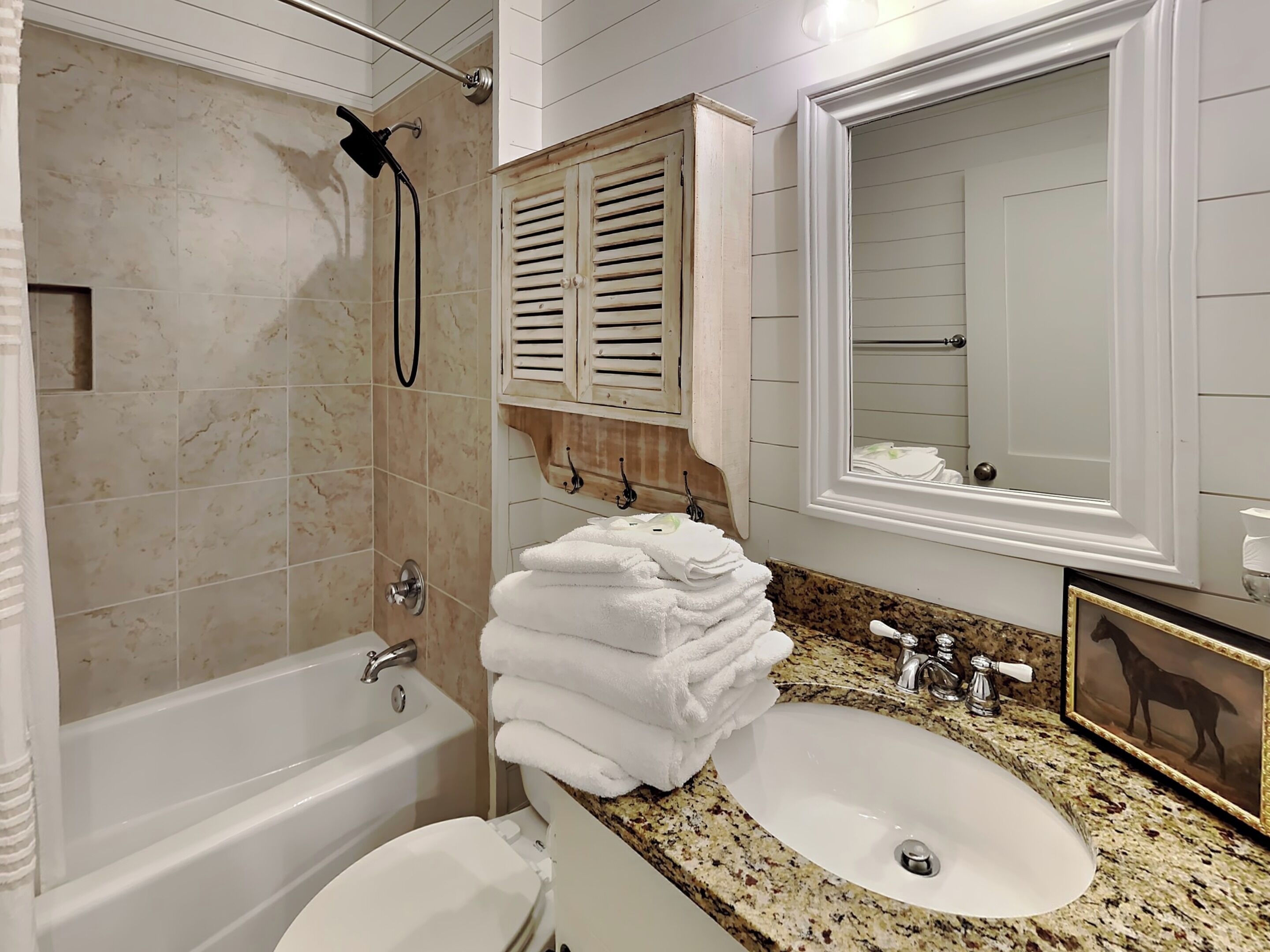 A bathroom with a bathtub, a sink, and a mirror.