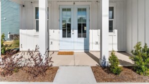 A white house with a front door and two windows on either side. - Coastal Haven A by Resort Collection (Panama City Beach)