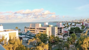 A coastal cityscape with modern buildings, a marina, and palm trees. - Get One Suites (João Pessoa)