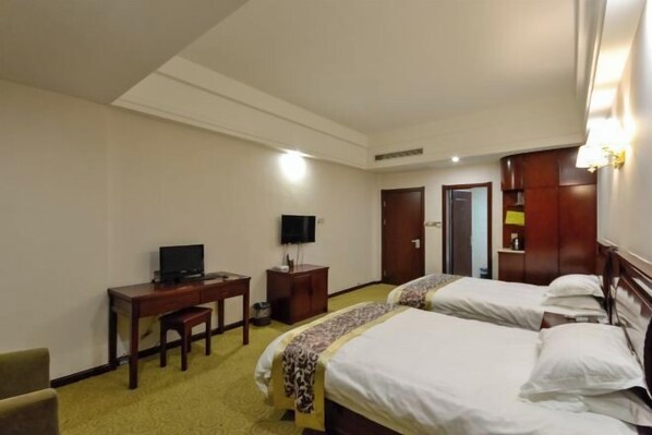 A hotel room with two beds, a desk with a chair, a television, and a wardrobe. - Xianju Baita Business Hotel (Xianju)
