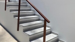 A modern staircase with wooden handrails and grey steps, leading to an upper level. - Casas de Juan (Cairu)