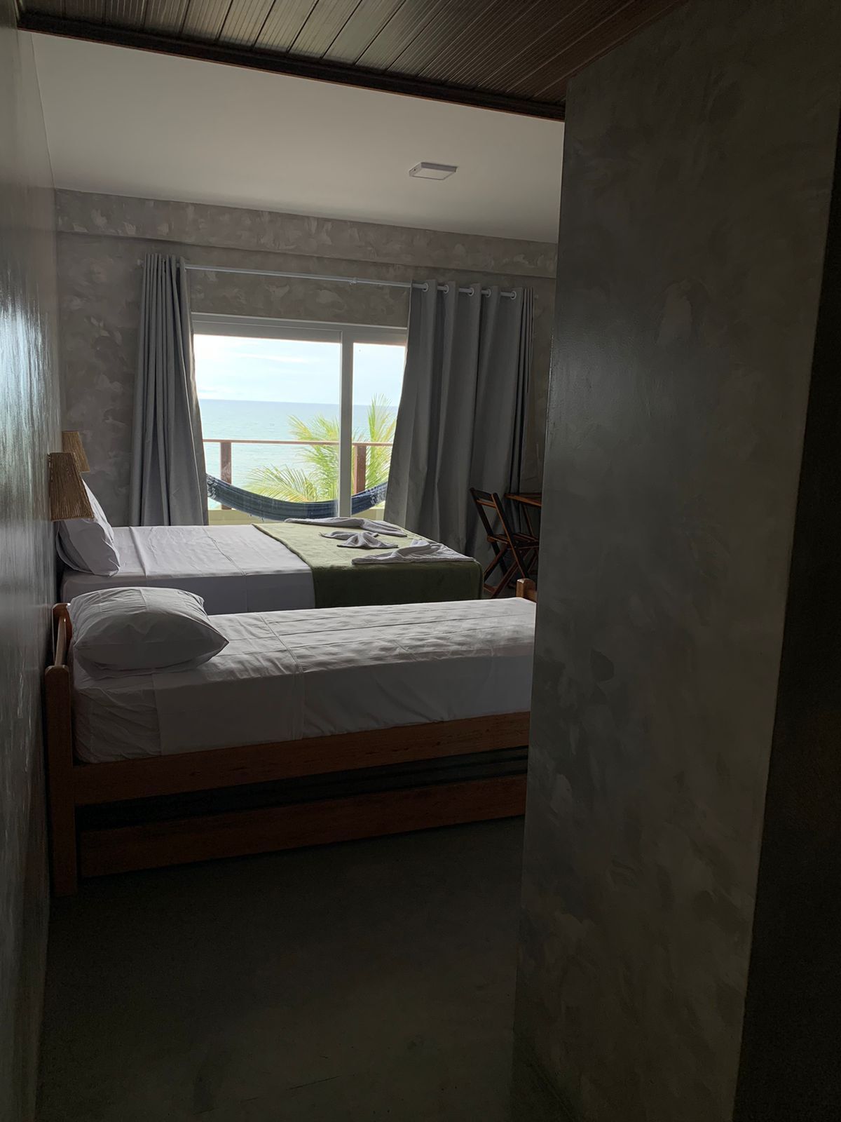 Ein Schlafzimmer mit zwei Betten, Meerblick und einer Hängematte.