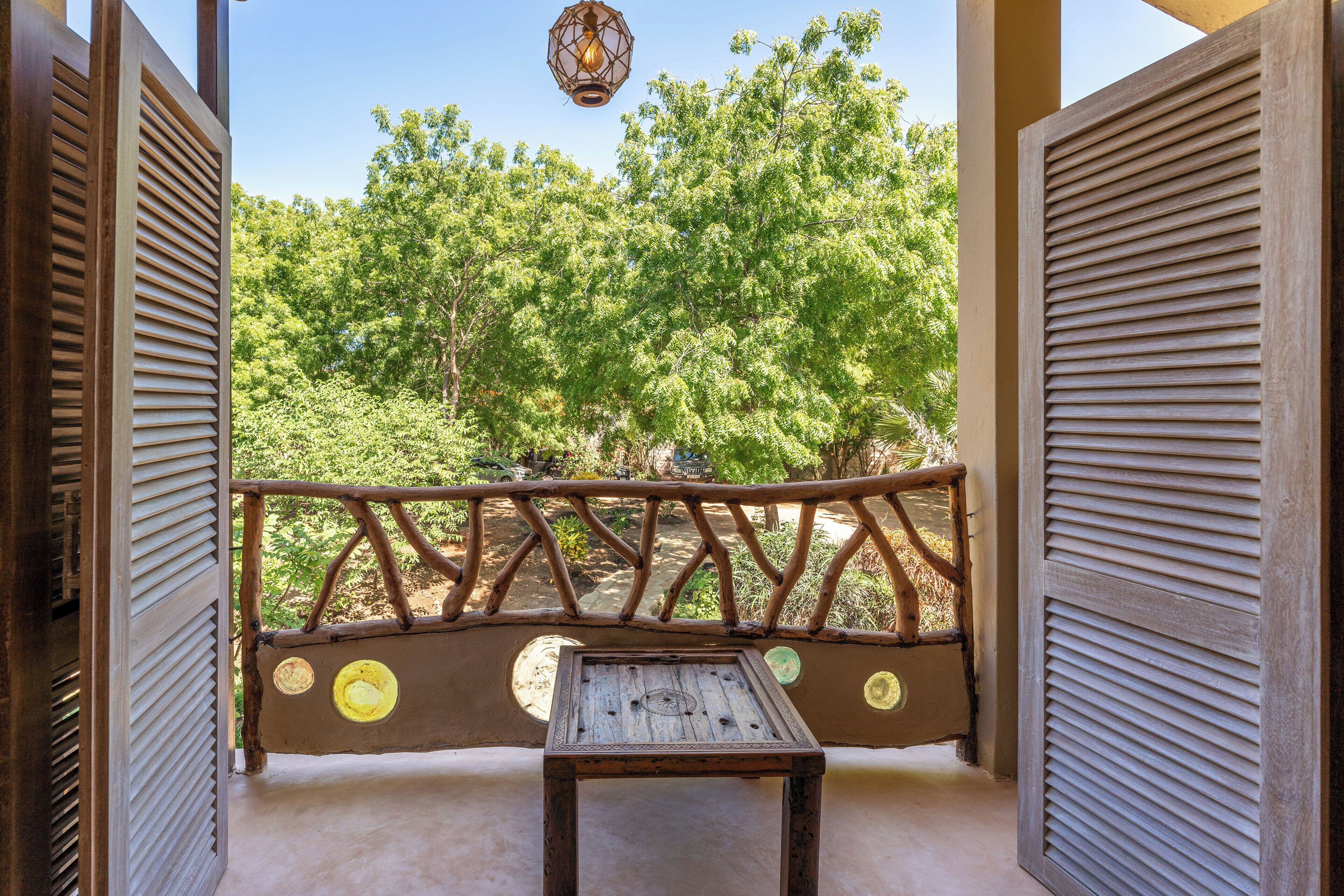 A balcony with a wooden table and a decorative railing.