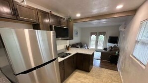 A compact kitchen with dark wooden cabinets, a stainless steel refrigerator, and a tiled floor. - LUXURY 2-bedroom house in brilliant Bisbee with BREATHE taking views (Bisbee)
