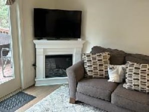 Una Smart TV, una chimenea, libros, una biblioteca de música