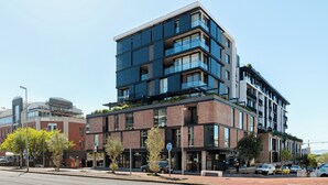 En flervåningsbyggnad med modern design, utrustad med stora fönster och balkonger.