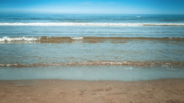 A beach with clear blue water and a sandy shore. - Charming BEACHFRONT condo in Galveston, 2 POOLS open year round, FITNESS CENTER (Galveston)
