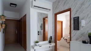 Une salle de bain moderne avec un mur en marbre, un grand miroir, un lavabo et des toilettes.