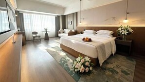 Une chambre d’hôtel moderne avec un grand lit, un bureau, une chaise et une vue sur l’extérieur.