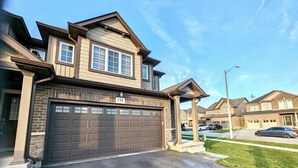A two-story house with a garage, a well-maintained lawn, and a clear sky. - Niagara Getaway 
4bdrm, 4bths. 18 min to Falls.
'Isla Paraiso Verde' (Thorold)