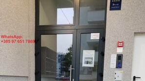 L’entrée d’un hôtel, avec une porte vitrée, un détecteur d’incendie et une serrure à clavier.