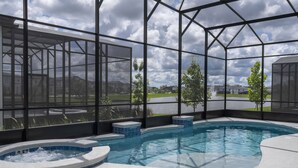 A swimming pool with a hot tub, surrounded by a glass enclosure with a view of a residential area. - Last Minute Disney! Private Pool, Hot Tub & Themed Bedrooms. Book Now! #119687 (Orlando)