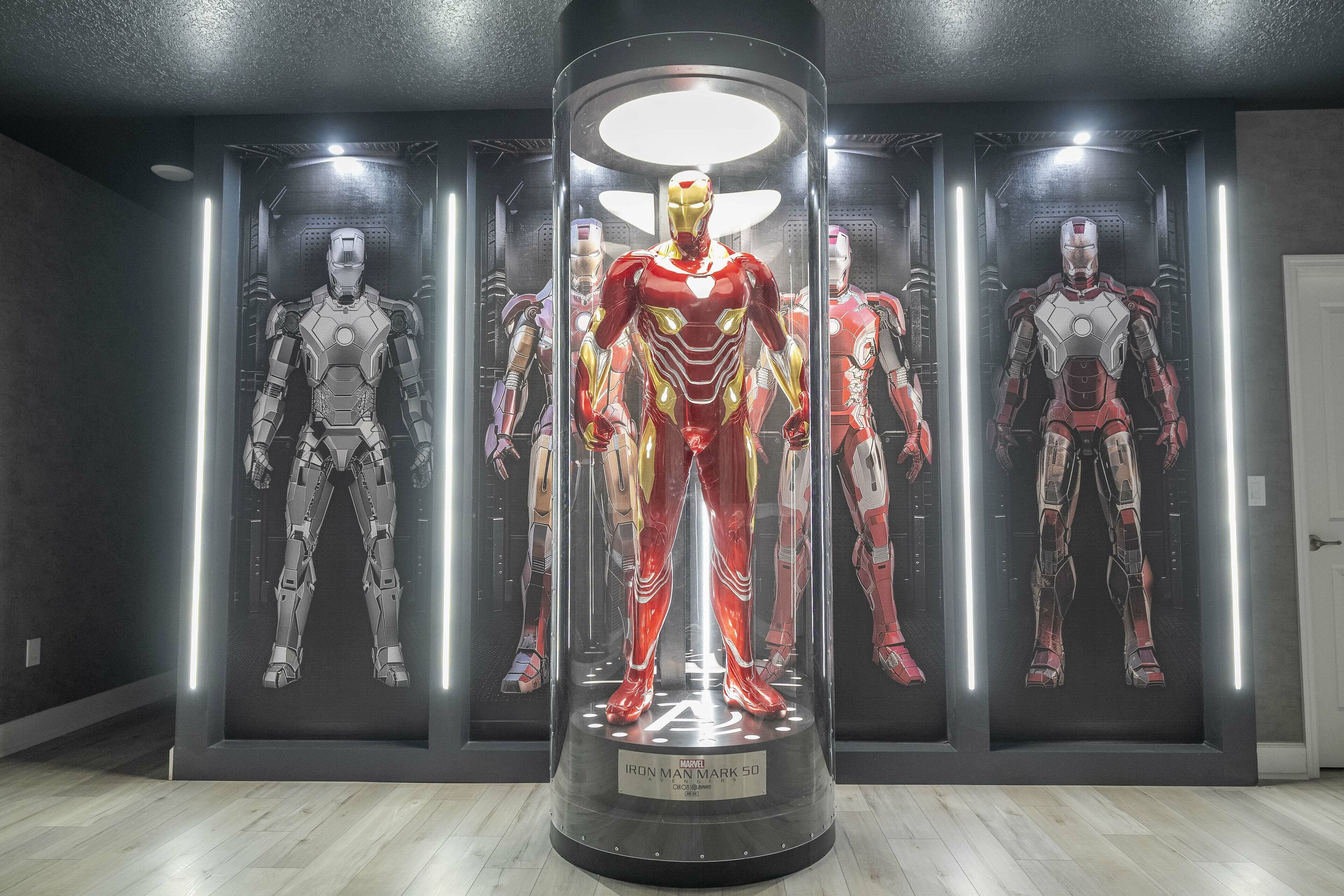 A display of Iron Man suits in a museum setting.