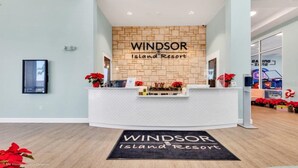 Un comptoir d’accueil à Windsor Island Resort, avec un mur en pierre en arrière-plan, un comptoir de réception et un paillasson.