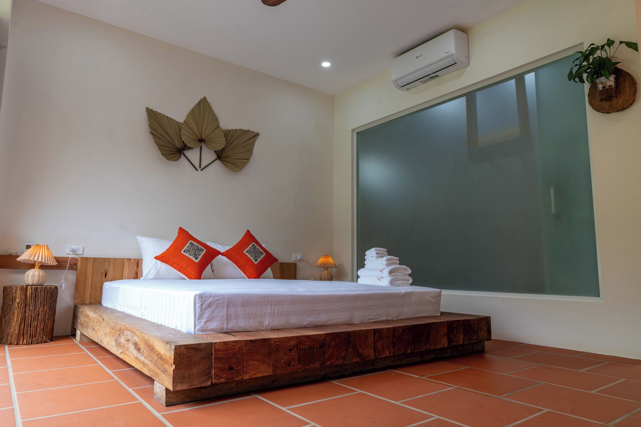A bedroom with a wooden platform bed, a large window, and a wall-mounted air conditioner.