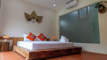 A bedroom with a wooden platform bed, a large window, and a wall-mounted air conditioner.