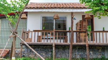 Una casa rústica con cimientos de piedra, balcón de madera y tejado de tejas.