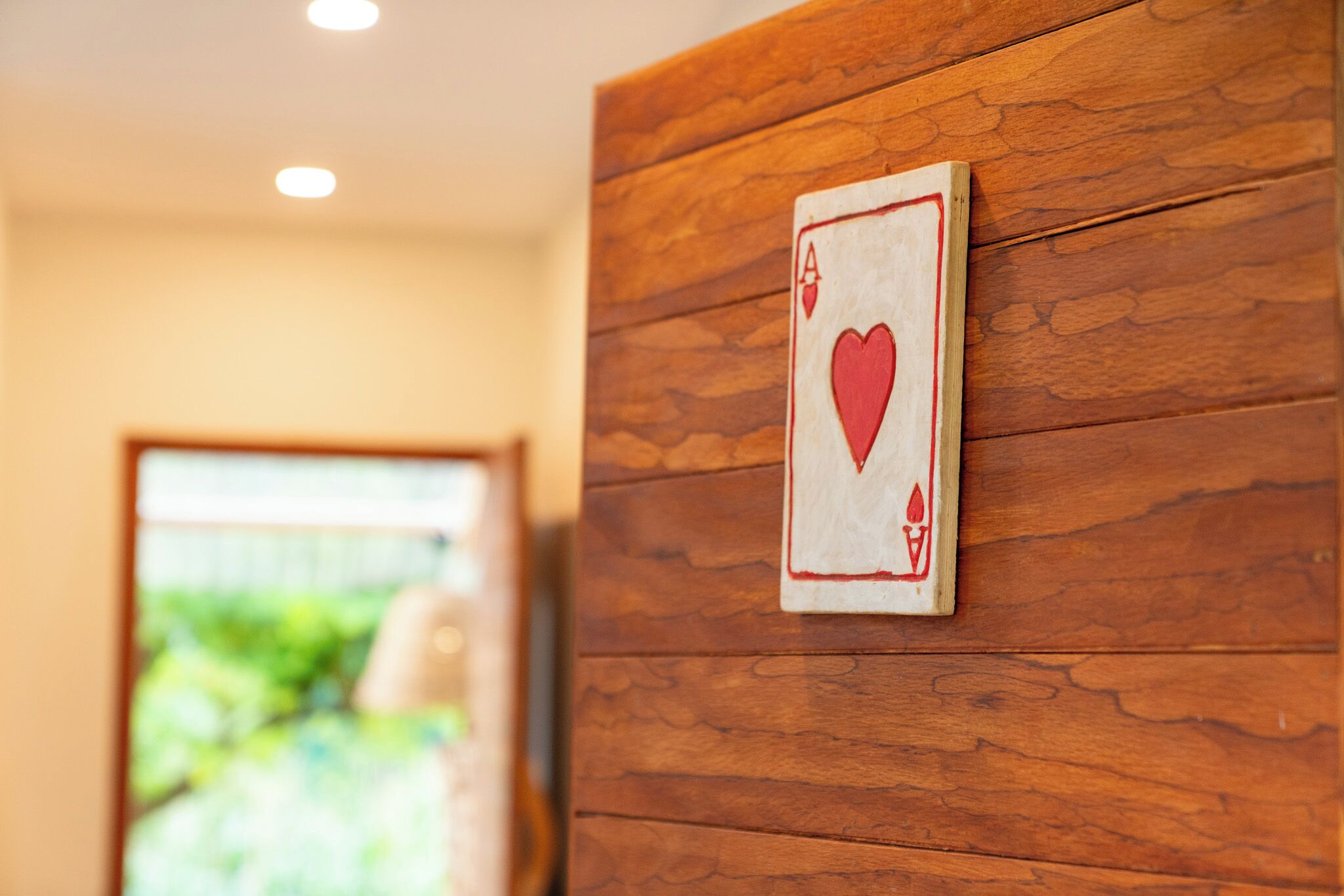 Pared de madera con una carta de juego que muestra un símbolo de corazón.