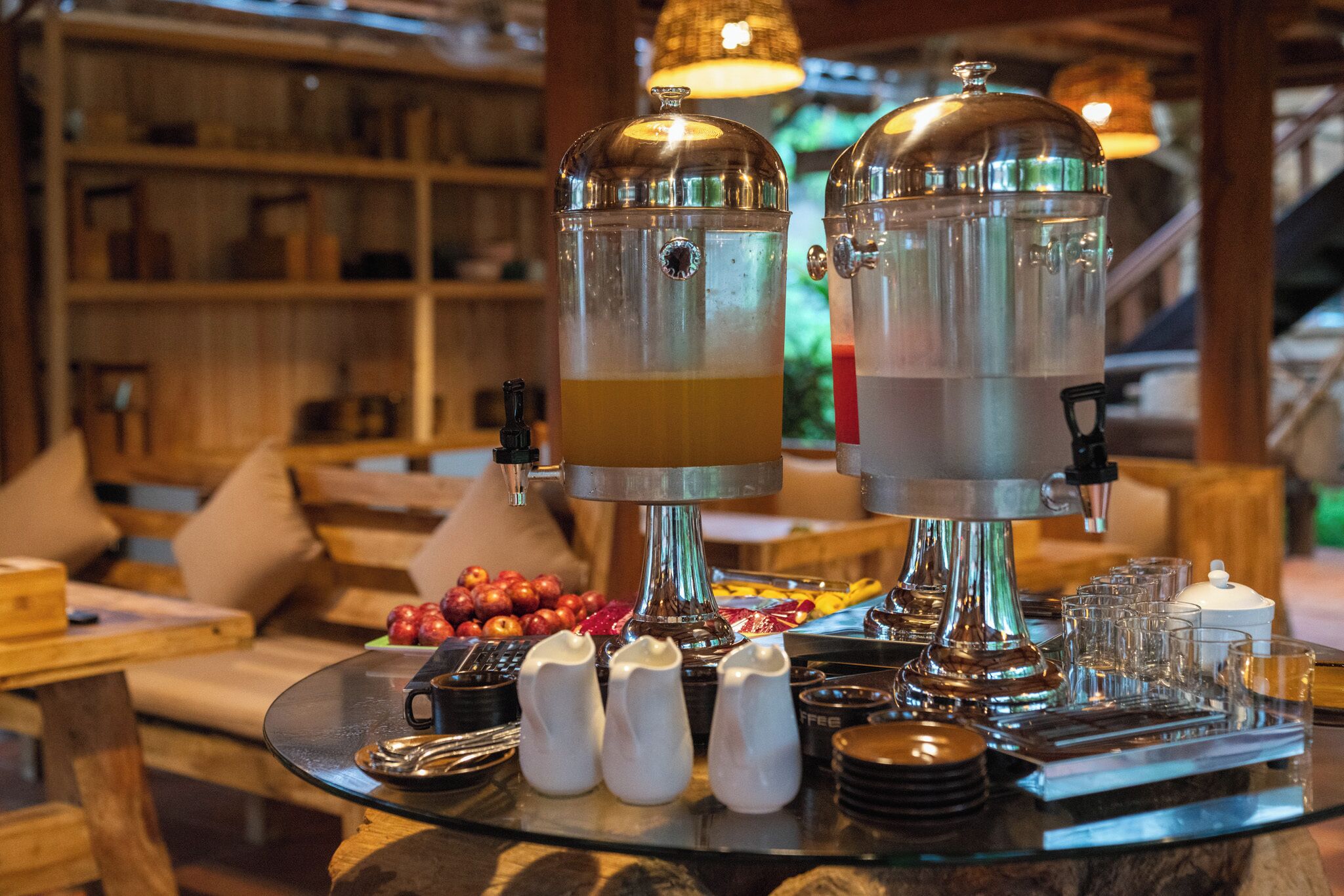 Ein reichhaltiges Frühstücksbuffet mit zwei Kaffeeautomaten, einer Auswahl an Früchten und verschiedenen Soßen.