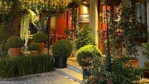 A building with a wooden facade, a sign reading "Británico", and a balcony with potted plants. - Hotel Boutique Britânico (Gramado)