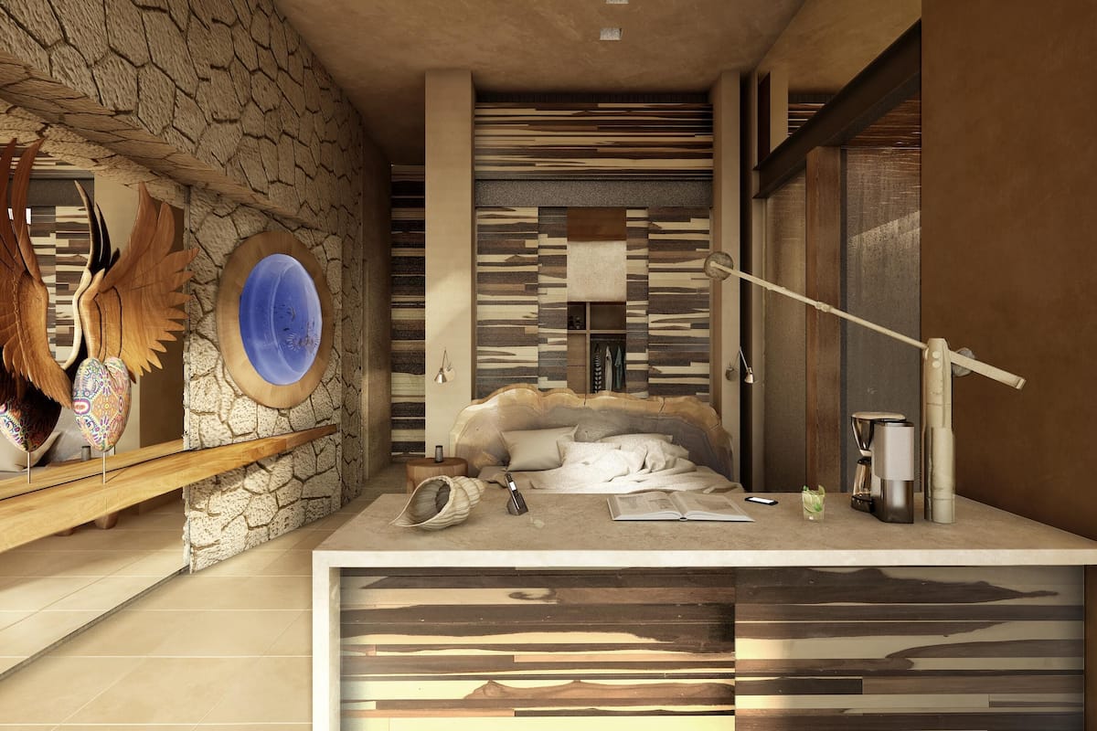 Ein modernes Badezimmer mit Steinwand, einem runden Spiegel, einem hölzernen Regal mit Dekoration und einem Bett mit weißem Kopfteil sowie einer Kaffeemaschine.