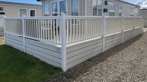Ein Wohnmobil mit weißem Deck und überdachter Veranda.