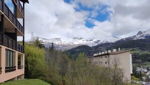 Un edificio moderno con balcón que da a un paisaje montañoso.