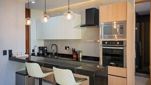 A modern kitchen with a central island, stainless steel appliances, and pendant lighting. - Sunny Puerto Vallarta Condo (Puerto Vallarta)