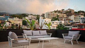 A rooftop terrace with a sofa, chairs, and a table. - Studio w/ Stunning Rooftop Pool (Puerto Vallarta)
