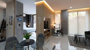 A modern living room with a glass dining table, a sofa, a TV, and a large window. - Studio w/ Stunning Rooftop Pool (Puerto Vallarta)
