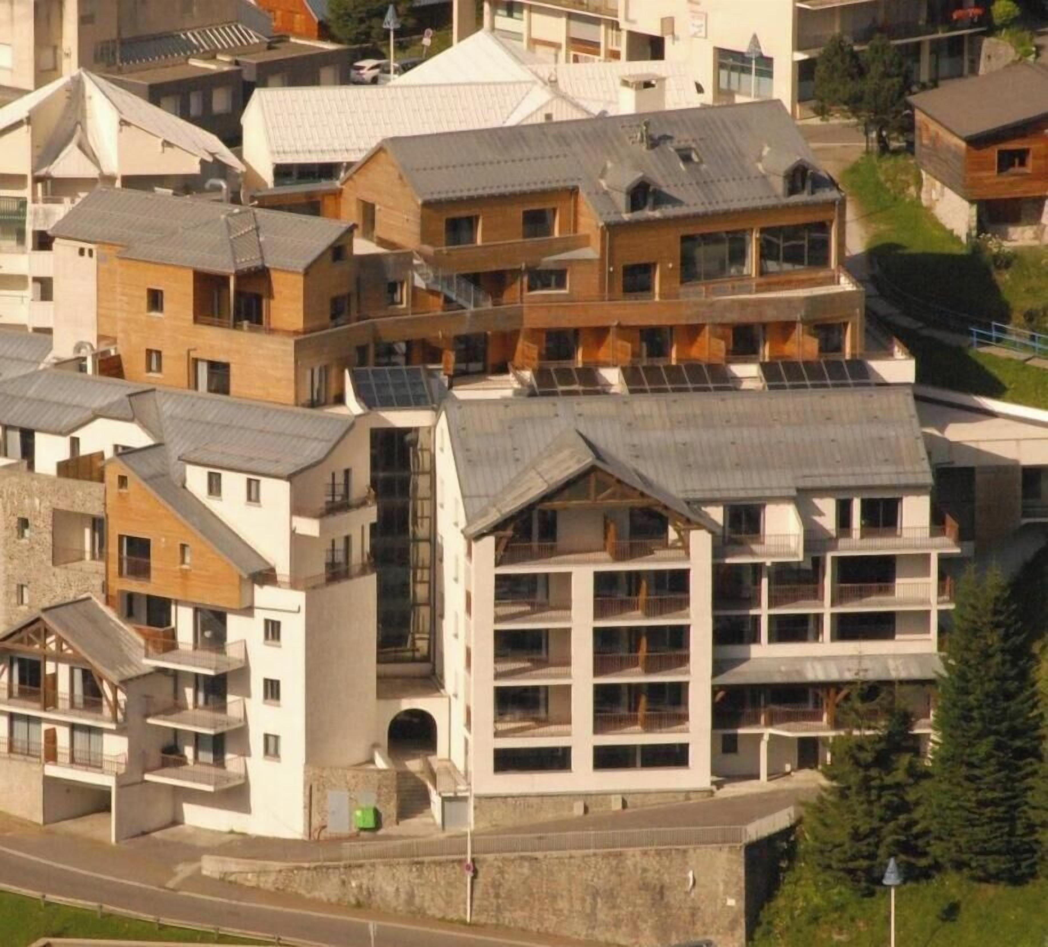 A residential area with multi-story buildings, some with visible balconies and solar panels.