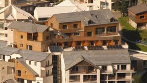 Un quartier résidentiel composé d’immeubles à plusieurs étages, dont certains sont dotés de balcons apparents et de panneaux solaires.