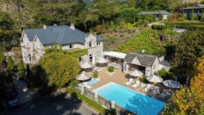 A large house with a swimming pool, outdoor seating, and a garden. - Pihopa Retreat (Nelson)