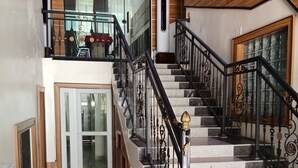 Et flerniveaulignende interiør med en imponerende trappe, en balkon med dekoreret loft og et moderne design.