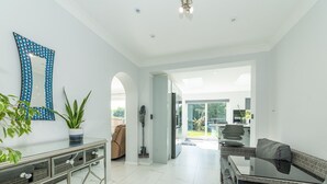 A spacious living area with a modern kitchen, a dining area, and a view of the backyard.
