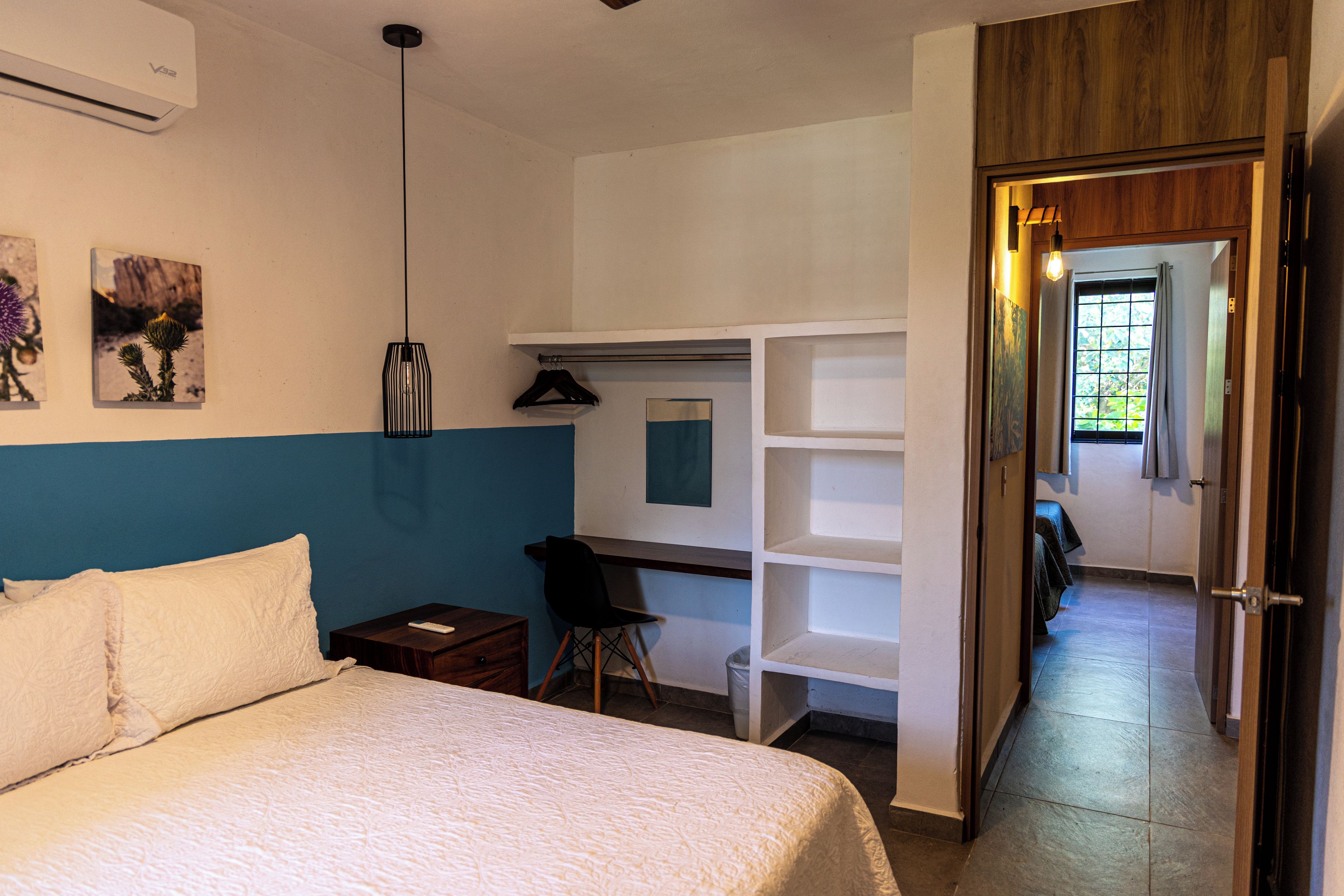 Un dormitorio con cama, escritorio y armario.