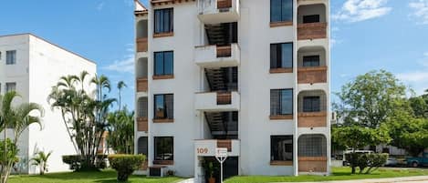 A multi-story building with a central staircase, balconies, and a sign indicating the number 109.