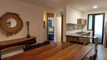 Una cocina moderna con una mesa de comedor de madera, una estufa integrada y vistas al área de estar.