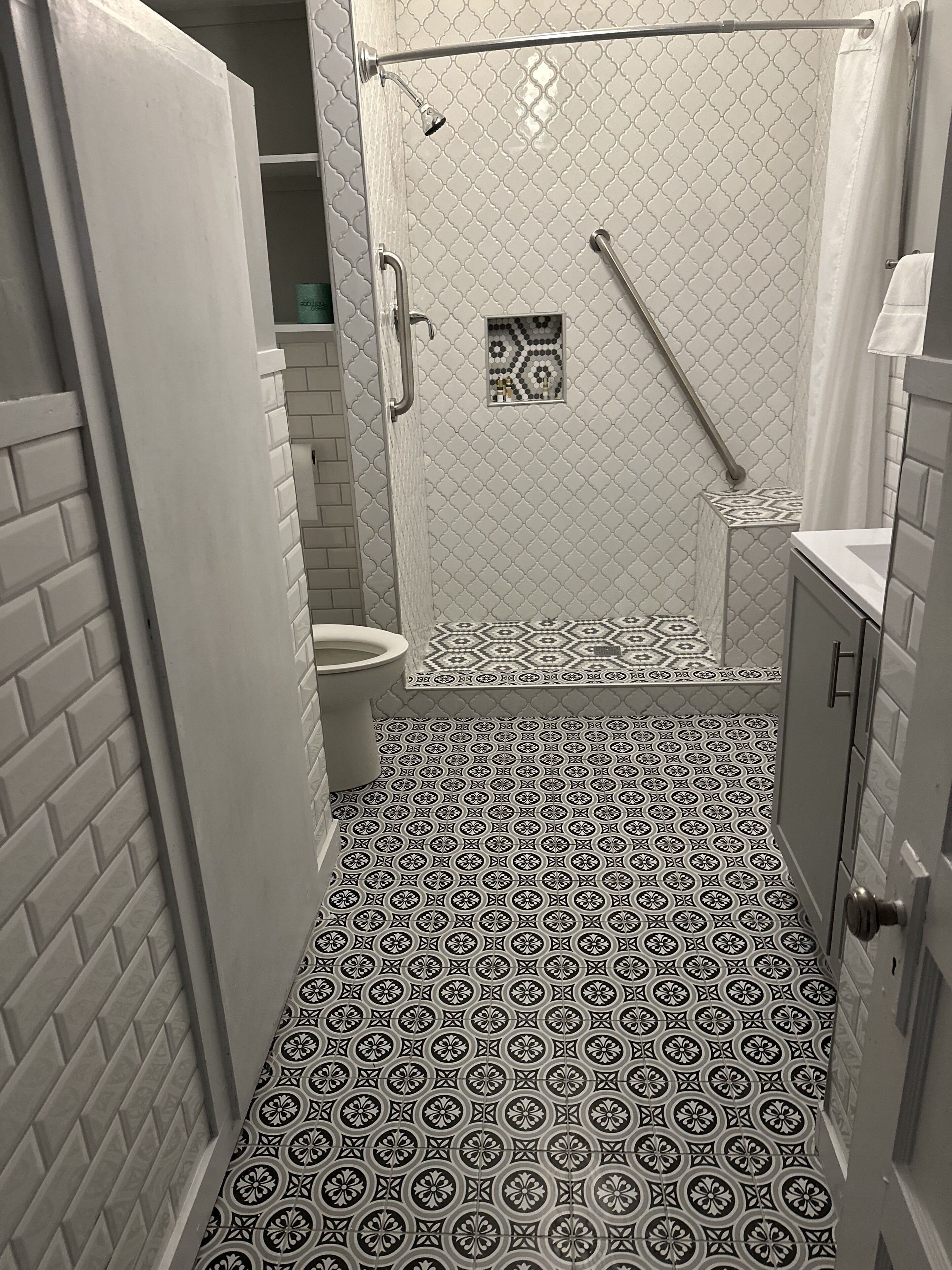 Un baño pequeño con ducha, inodoro y lavamanos.