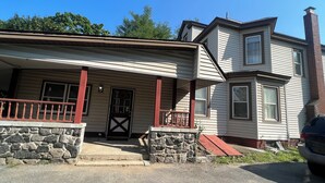 A two-story house with a porch, stone steps, and a chimney. - Cozy, Private1-bedroom in charming Schenectady with Private Bathroom  (Schenectady)
