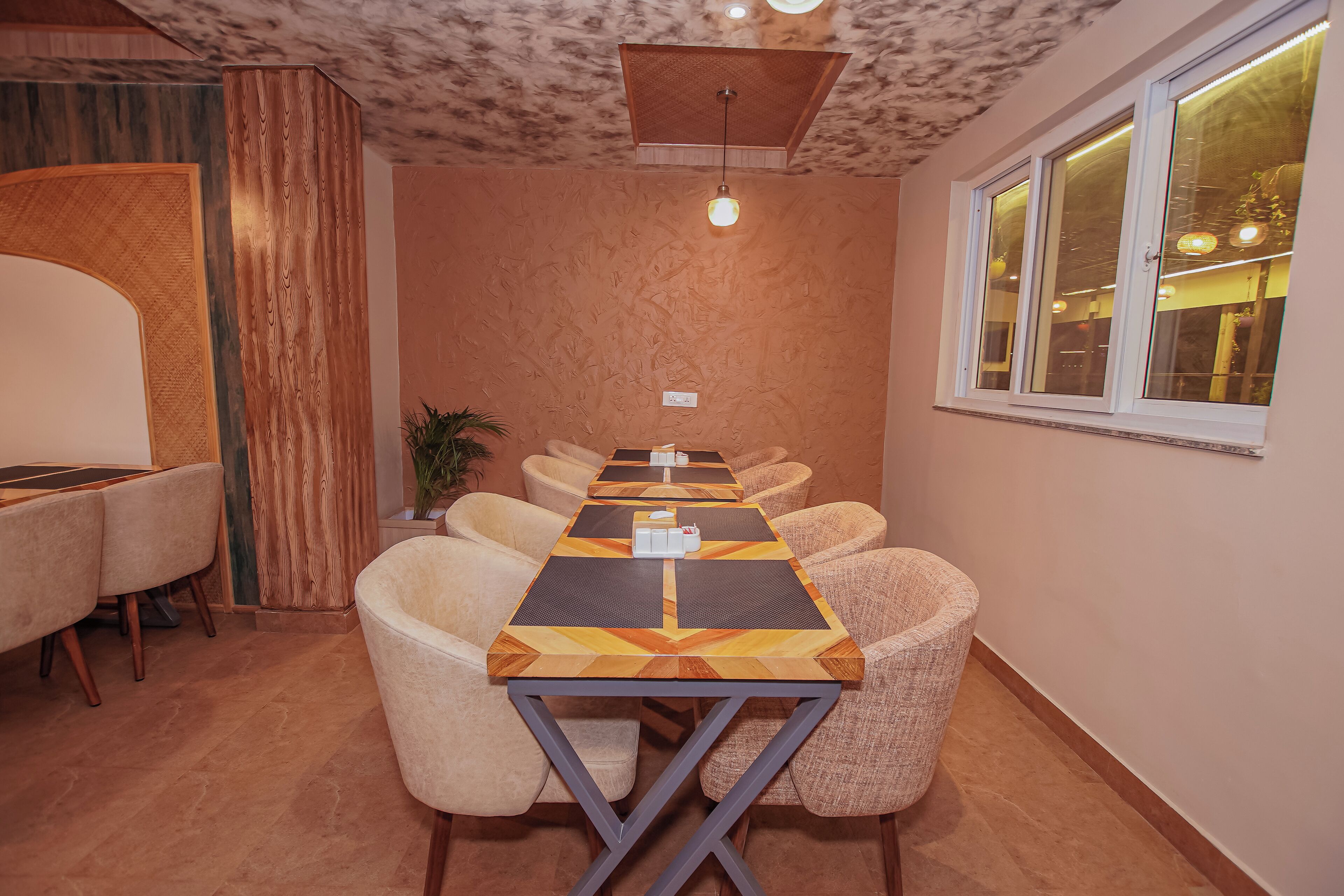 A conference room with a long table, multiple chairs, and a ceiling light fixture.