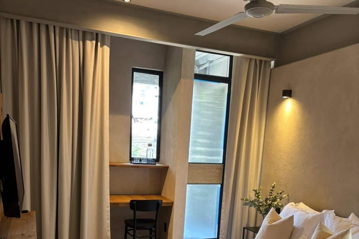 Una habitación de hotel moderna con una cama grande, un escritorio y una ventana.