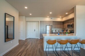 A modern kitchen with a central island, stainless steel appliances, and wooden cabinets.