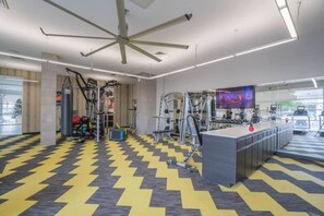 A gym with exercise equipment, a ceiling fan, and a television screen. - Downtown Phoenix Retreat | Walk to Arts District (Phoenix)