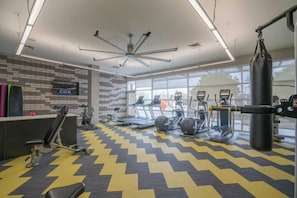 A gym with exercise equipment, a punching bag, and a COX sign on the wall. - Downtown Phoenix Retreat | Walk to Arts District (Phoenix)