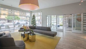 A modern lobby with a large sofa, a coffee table, and a Christmas tree. - Downtown Phoenix Retreat | Walk to Arts District (Phoenix)